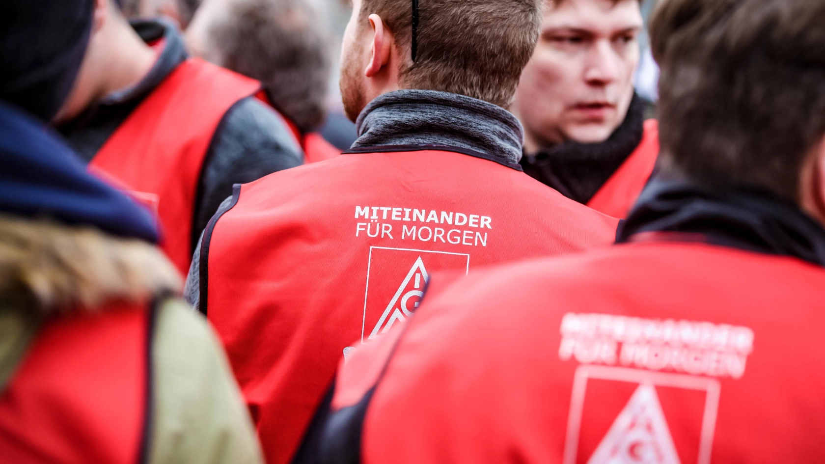 Ein Mann mit einer roten Weste, auf der "miteinander für morgen" steht.